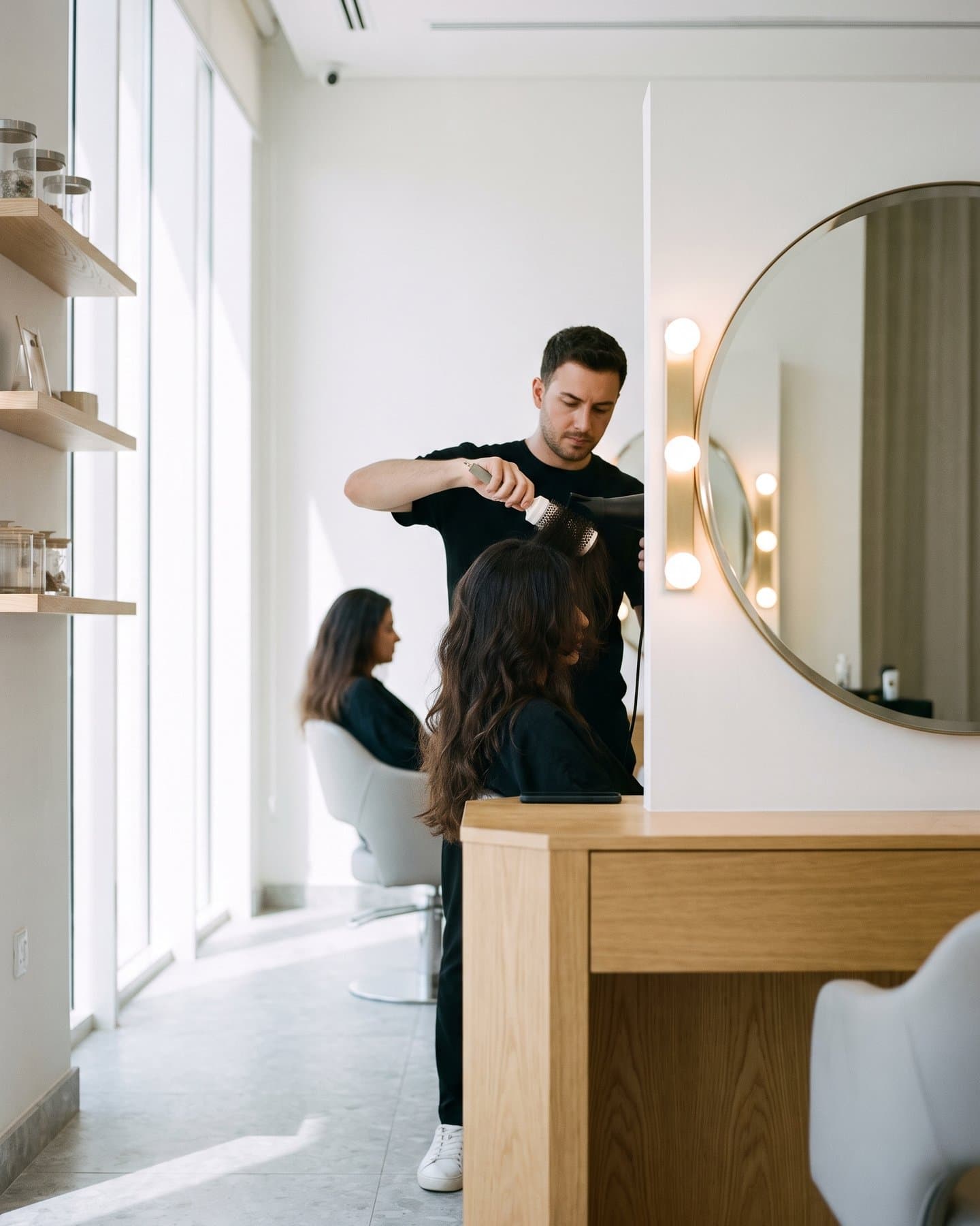 Hair stylist finishing a blow-dry in a salon